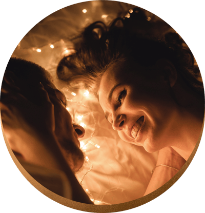 Couple smiling and looking into each other's eyes in bed